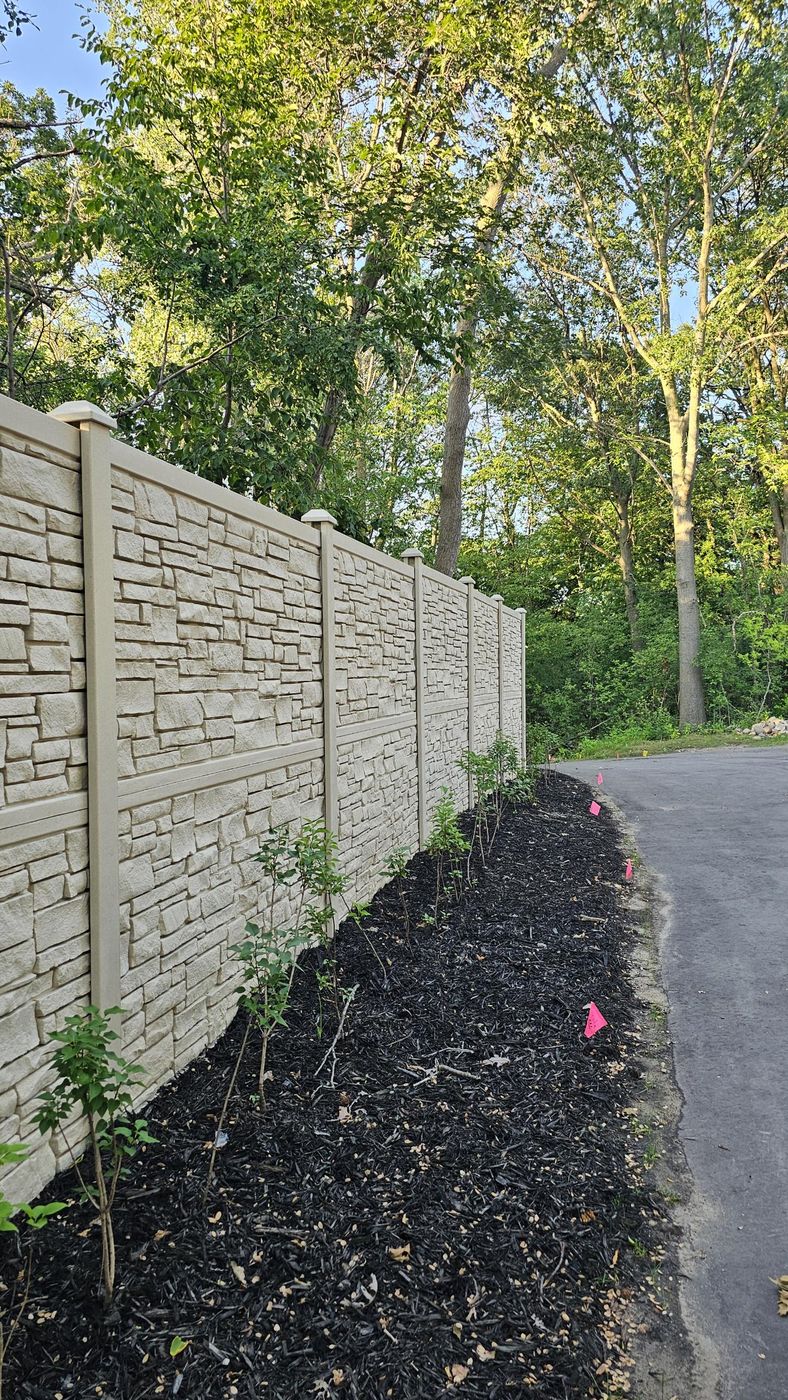 Finished stone-look privacy fence with new plantings