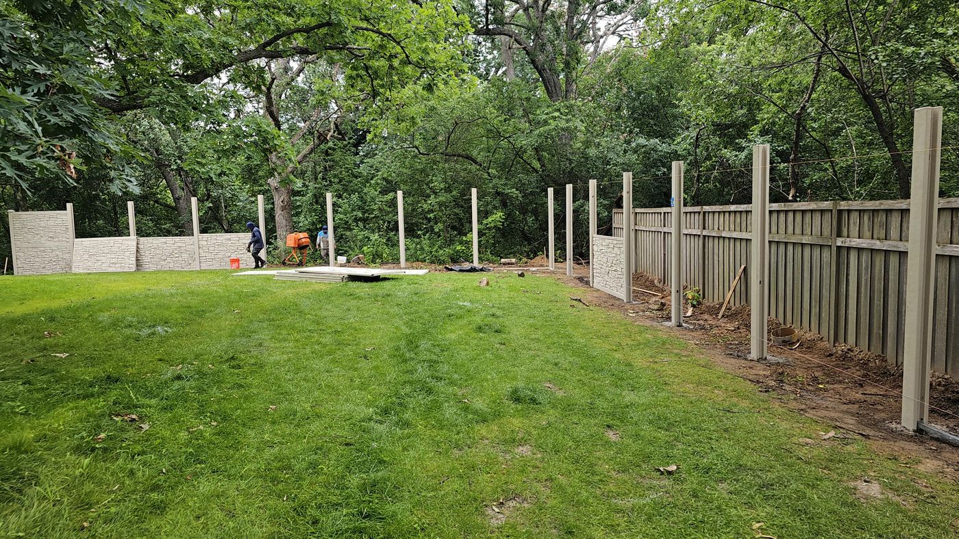Posts set in concrete, replacing the old wood fence